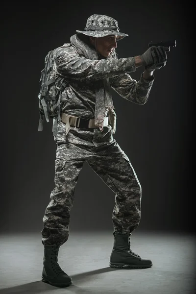 Солдат спецназа с пистолетом на темном фоне — стоковое фото