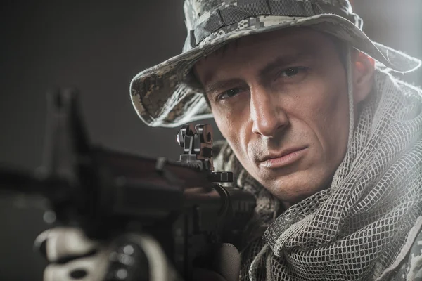 Солдат спецназа с пулеметом на темном фоне — стоковое фото