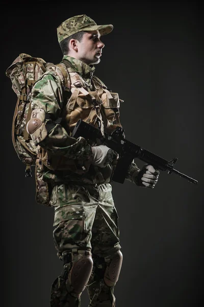 Asker adam tutun makineli tüfek karanlık bir arka plan üzerinde