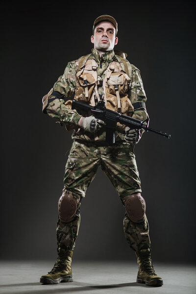 Soldier man hold Machine gun on a  dark background