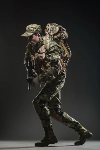 Soldat mannen hålla kulspruta på en mörk bakgrund — Stockfoto