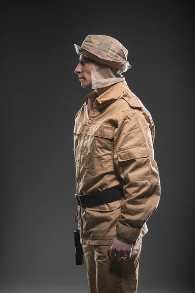 Солдат с пистолетом на темном фоне — стоковое фото