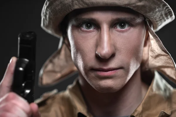Солдат с пистолетом на темном фоне — стоковое фото