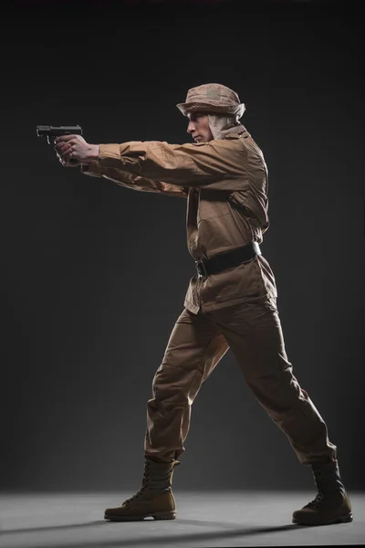 Soldier with a gun takes aim on dark background — Stock Photo, Image