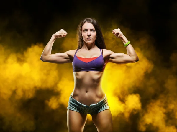 Hermosa joven deportista mujer mostrando músculo —  Fotos de Stock