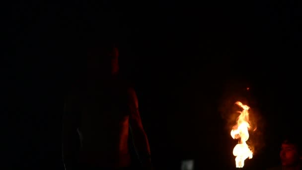 Артист огненного шоу раздувает огонь в темноте — стоковое видео