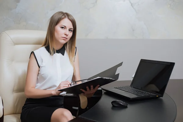 Сексуальна бізнес-леді сидить за столом в офісі — стокове фото