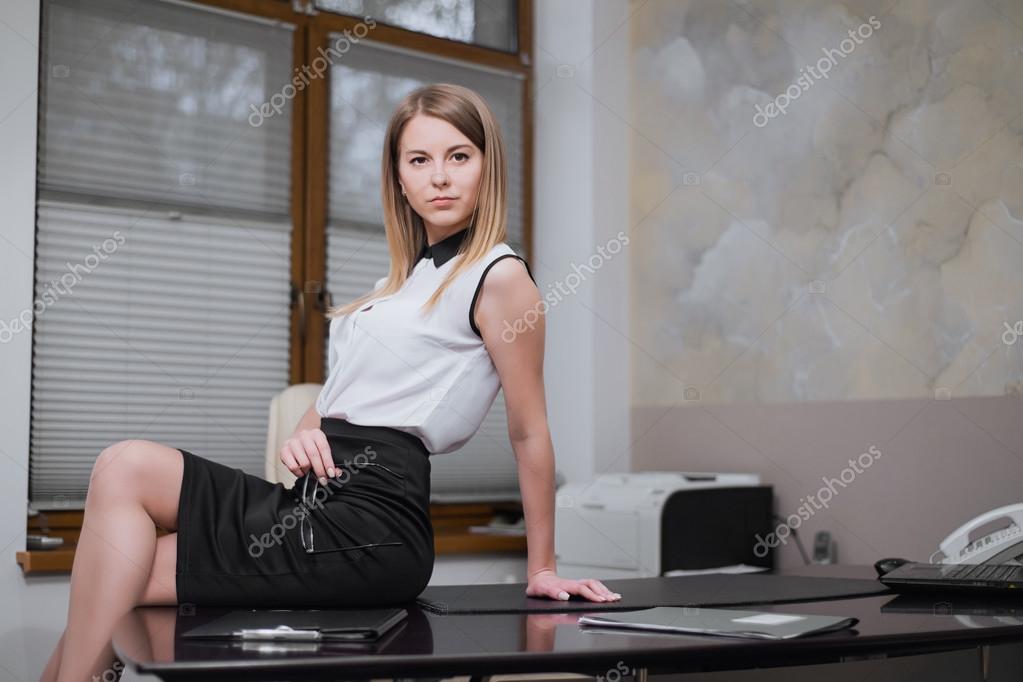 Sexy business woman sitting on the table in office — Stock Photo © Sheikoevgeniya 118029306