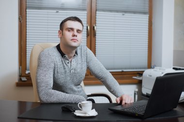 Office çalışan serbest meslek Danışma ve dizüstü bilgisayar üzerinde çalışan kahve molası sırasında ofisinde oturur