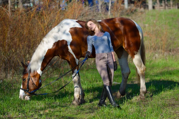 Menina desportista e seu cavalo na primavera — Fotografia de Stock