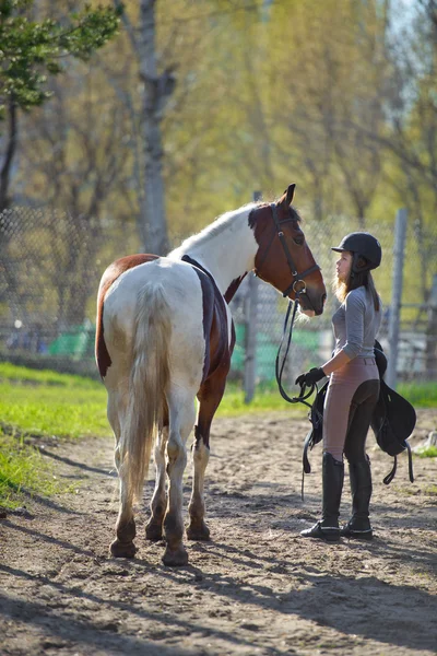Flicka idrottskvinna och hennes häst tillbaka till stallet efter ridning — Stockfoto