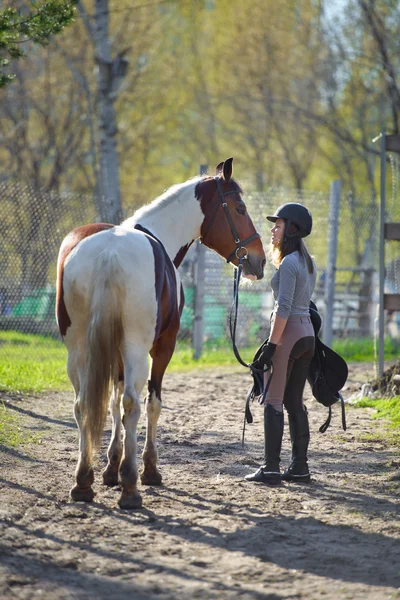 Flicka idrottskvinna och hennes häst tillbaka till stallet efter ridning — Stockfoto