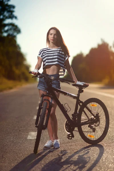 Mädchen auf einem Fahrrad bei Sonnenuntergang — Stockfoto