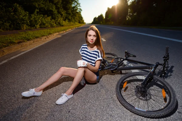 Fille avec un vélo au coucher du soleil — Photo