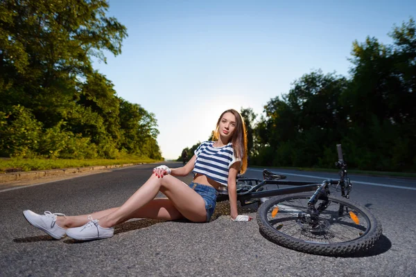 Chica con una bicicleta al atardecer — Foto de Stock