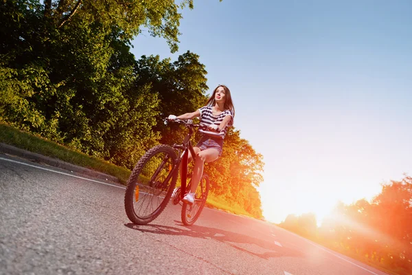 Mädchen auf einem Fahrrad bei Sonnenuntergang — Stockfoto