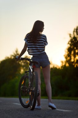 gün batımında bisikletle kız