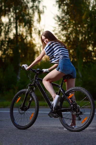 Flicka på cykel i solnedgången — Stockfoto