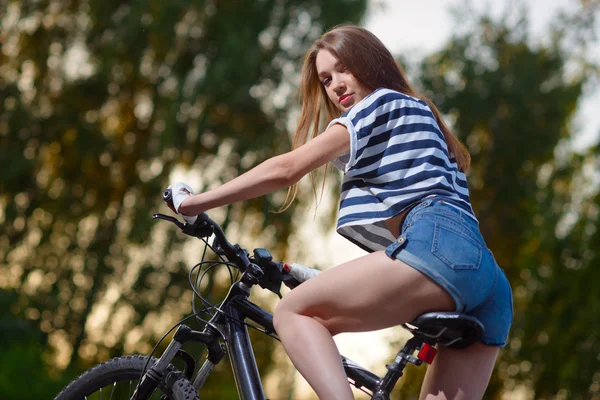 Fille sur un vélo au coucher du soleil — Photo