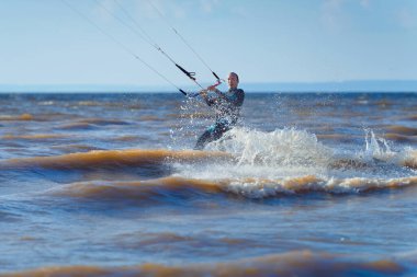 Uçurtma kaykayı. Dalgalarda sörf yapan bir uçurtma sörfçüsü. Orta yaşlı bir adam uçurtma üstünde dalgalara binmekten hoşlanır..