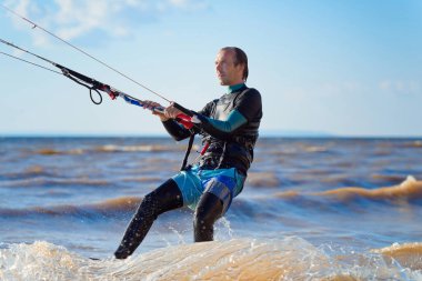 Uçurtma kaykayı. Dalgalarda sörf yapan bir uçurtma sörfçüsü. Orta yaşlı bir adam uçurtma üstünde dalgalara binmekten hoşlanır..