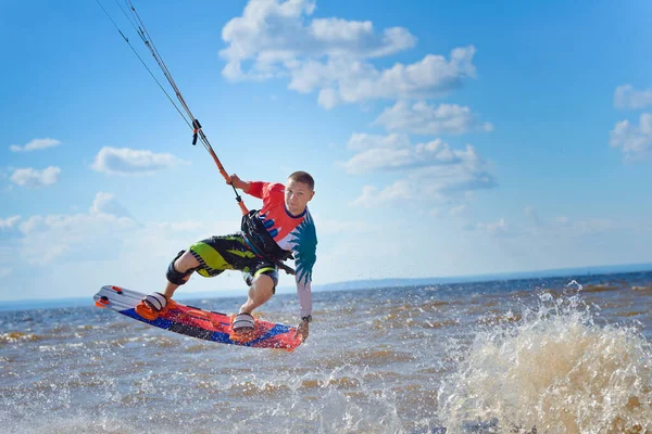 Kiteboarden Een Jonge Man Kitesurfer Geniet Van Het Rijden Golven Rechtenvrije Stockfoto's