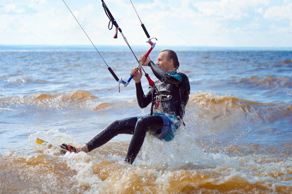 Kiteboarding. A kite surfer rides the waves. A middle-aged man enjoys riding the waves on a kite.