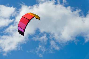 Arkaplanda renkli bir uçurtma süzülür..