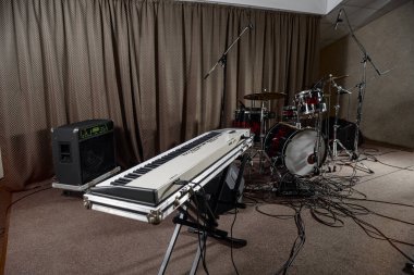 Sentezleyicinin klavyesi sahnede müzik ekipmanları arasında duruyor..