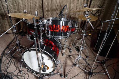 Davul seti prova sahnesinde, kahverengi bir perdenin arkasında..