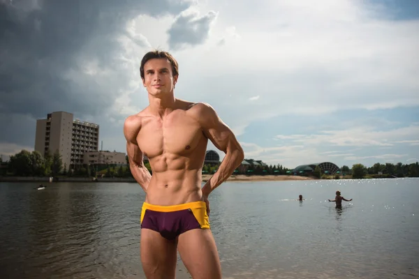 Retrato de um homem sexy desportivo, atlético e musculoso em calções de banho — Fotografia de Stock