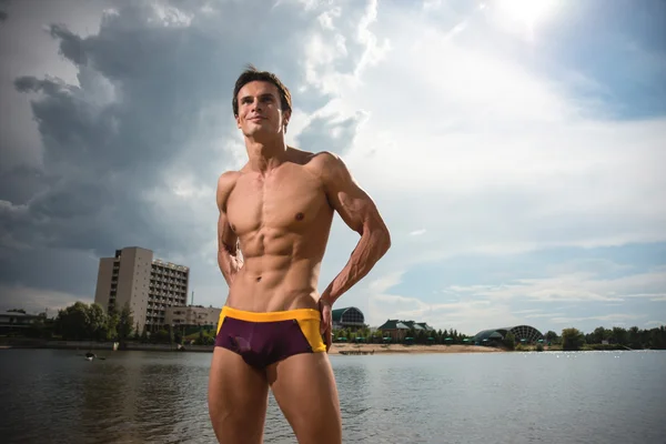 Portret van een sportief, atletisch, gespierde sexy man in swimtrunks — Stockfoto