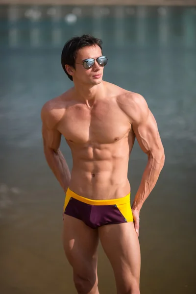 Retrato de um homem sexy desportivo, atlético e musculoso em calções de banho — Fotografia de Stock