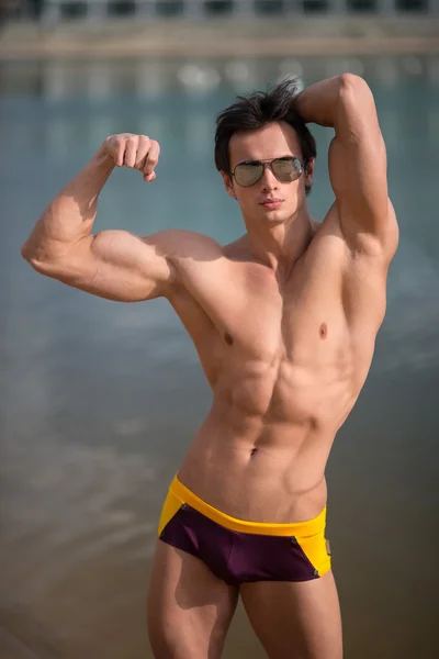 Portret van een sportief, atletisch, gespierde sexy man in swimtrunks — Stockfoto