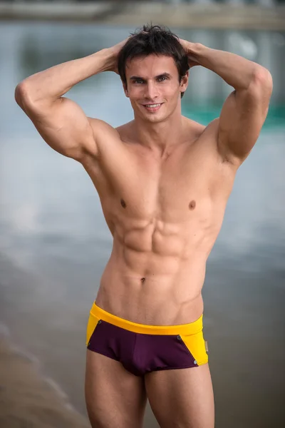 Portret van een sportief, atletisch, gespierde sexy man in swimtrunks — Stockfoto