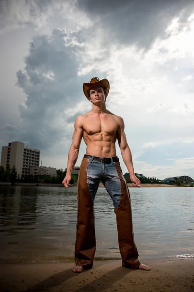 Sportif, atletik, kaslı seksi adam bir kovboy kıyafeti