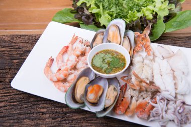 Tay yemek menüsü, baharatlı sos ile karışık deniz ürünleri ahşap plaka üzerinde Tay geleneksel gıda