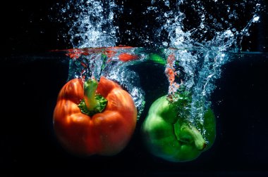 tatlı biber damla suya siyah arka plan üzerine.