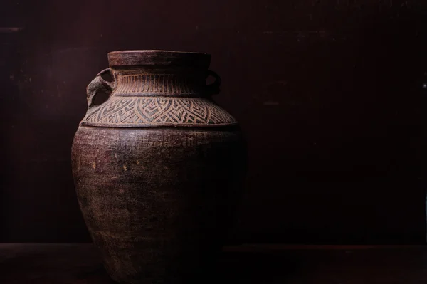 Earthenware jug standing on dark room or tiles  with copyspace — Stock Photo, Image