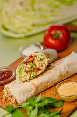 Tahtada sebze ve soslu taze tavuk dürümü..