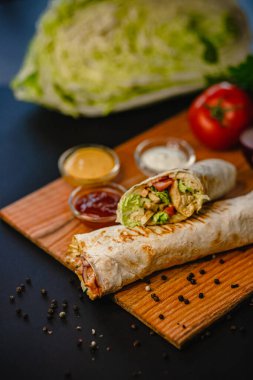 Tahta üzerinde çeşitli soslarla nefis tavuk dürümü..