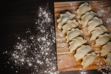 Ahşap tahtada ev yapımı hamur tatlısı ve geleneksel pişirme için un tozu..
