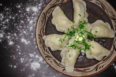 Kırsal tabakta geleneksel Ukrayna hamur tatlısı, otlar ve tereyağı..