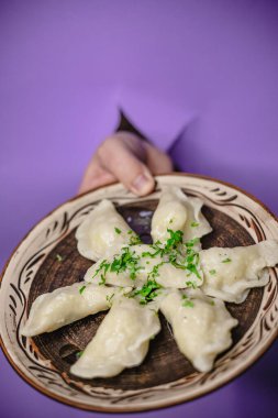 Mor arka planda taze otlu ev yapımı hamur tatlısı tabağı..