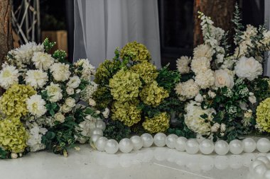 Yeşil ve beyaz ortanca çiçekleri ve incileri olan zarif bir çiçek düzenleme..