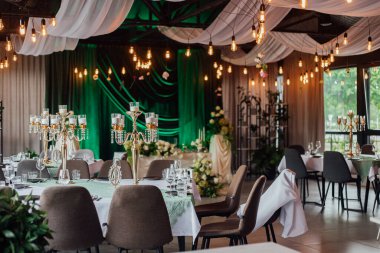 Yeşil perdeli ve mum ışıklı bir düğün resepsiyonu..