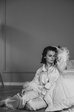 Şık, beyaz bir bayan, yatak odasında, yerde oturuyor..