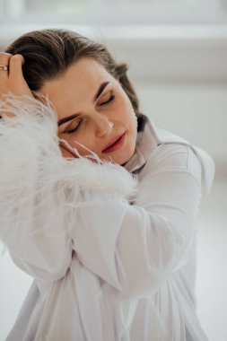 Beyaz tüylü giysili beyaz kadın içeride huzur içinde dinleniyor..