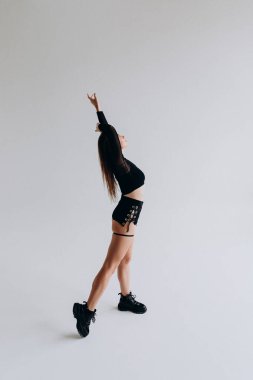 Contemporary dancer in a dynamic pose wearing stylish black outfit.