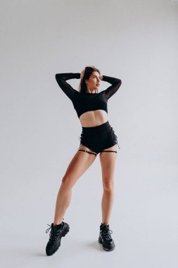 Kendine güveni tam bir kadın şık siyah fitness kıyafeti giymiş, atletik moda sergiliyor..